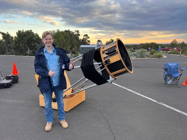 Chad Eisinger with a large Dobsonian telescope at dusk