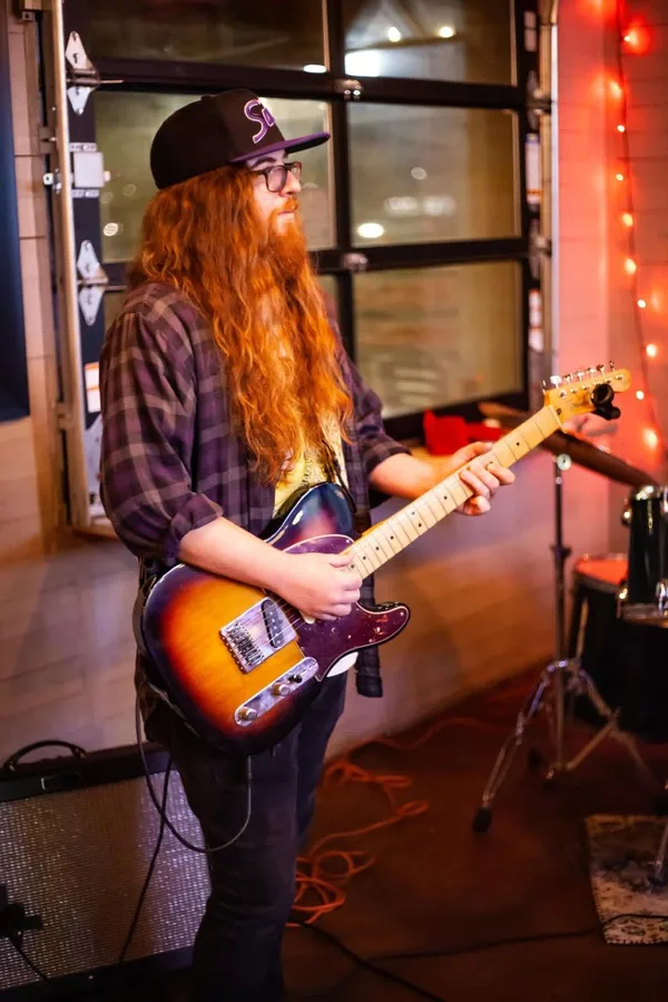 Sean playing electric guitar at a rehearsal