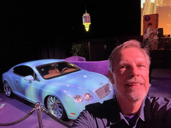 Tim D. Binegar in front of a light blue Bentley coupe